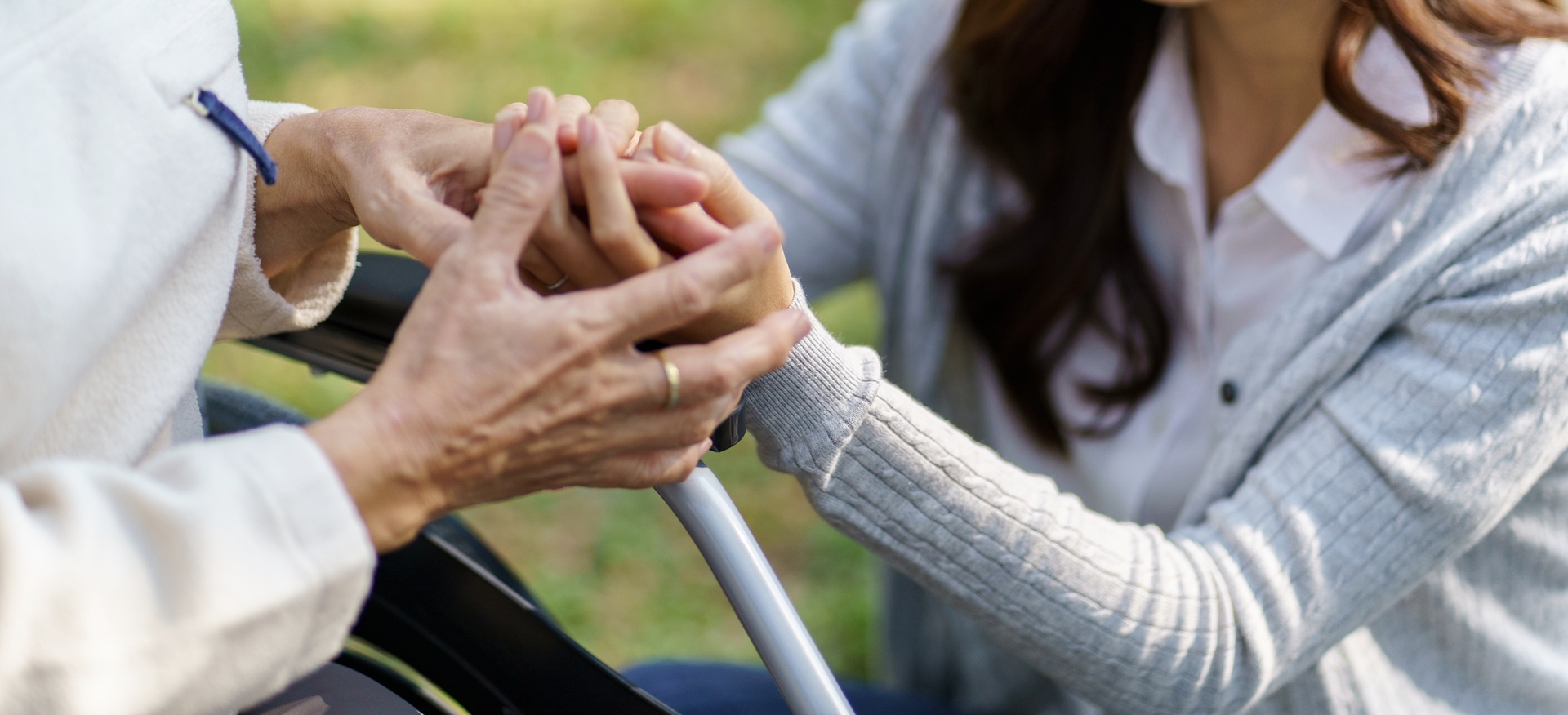 Asian senior woman in wheelchair with happy daughter.