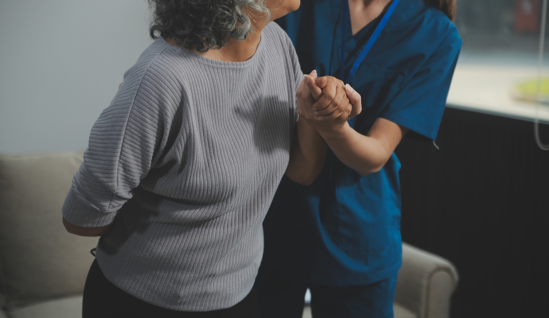 Female caregiver doing regular check-up of senior woman in her home.